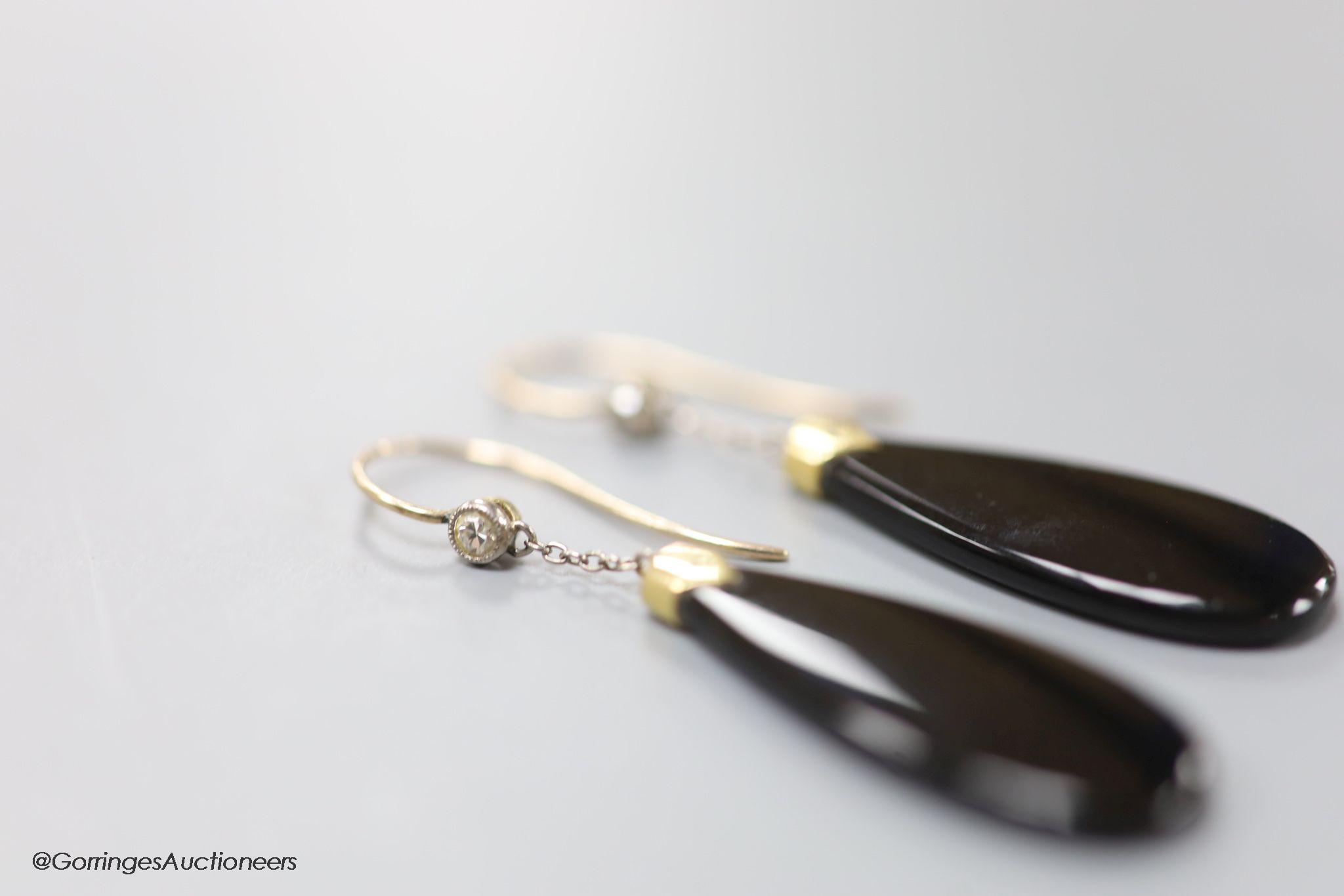 A pair of early 20th century yellow metal mounted black onyx and diamond set pear shaped drop earrings, 40mm, gross 4.6 grams.